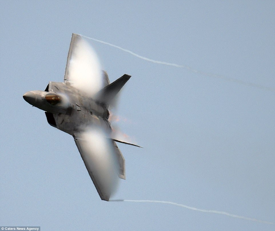 A fighter jet making a hard turn with visible wing-tip vortices and condensation over the wing