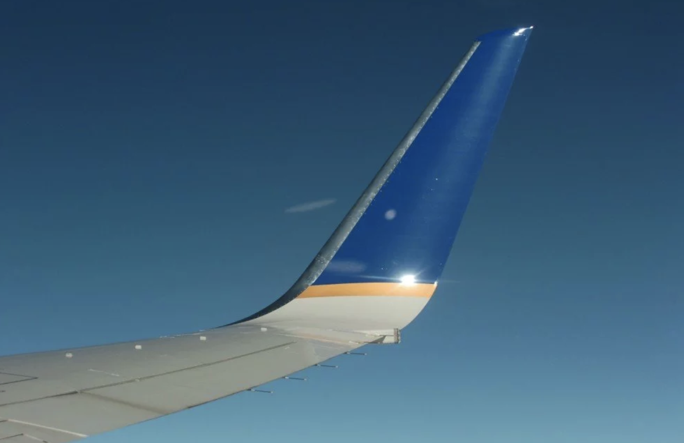 Diagram showing a winglet at the tip of a wing preventing high-to-low pressure airflow around the tip