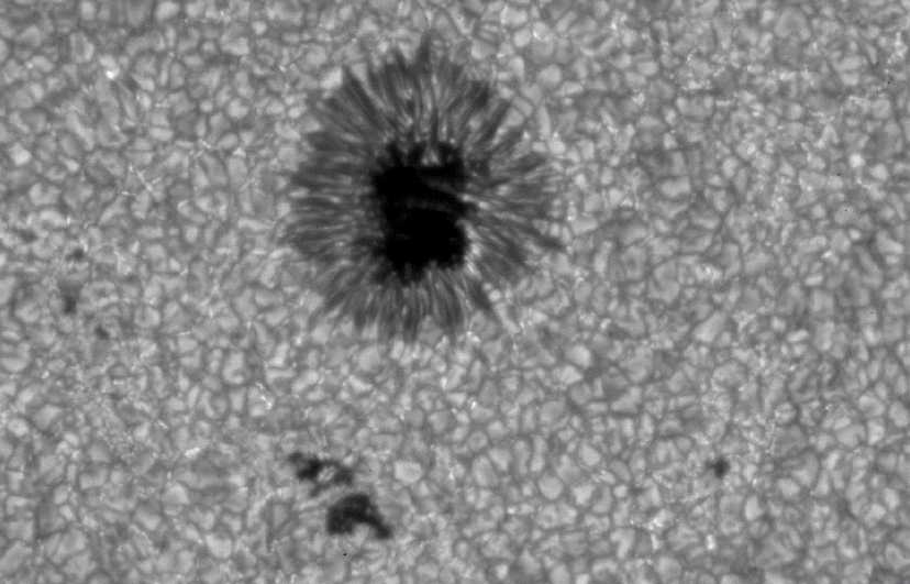 Close-up photograph of a sunspot — dark center cooler than surrounding surface